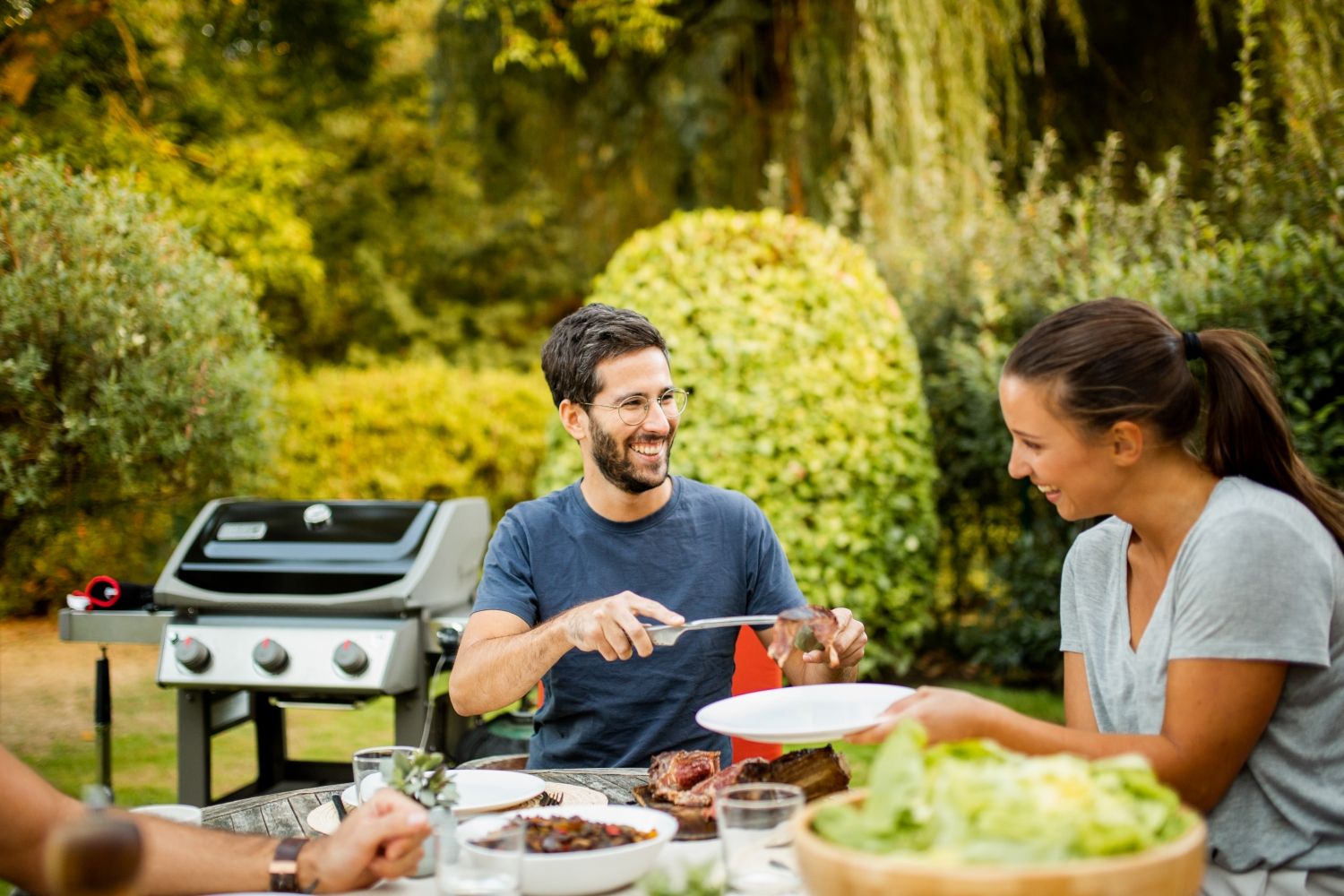 Grill gazowy Weber Spirit oraz ludzie przy stole