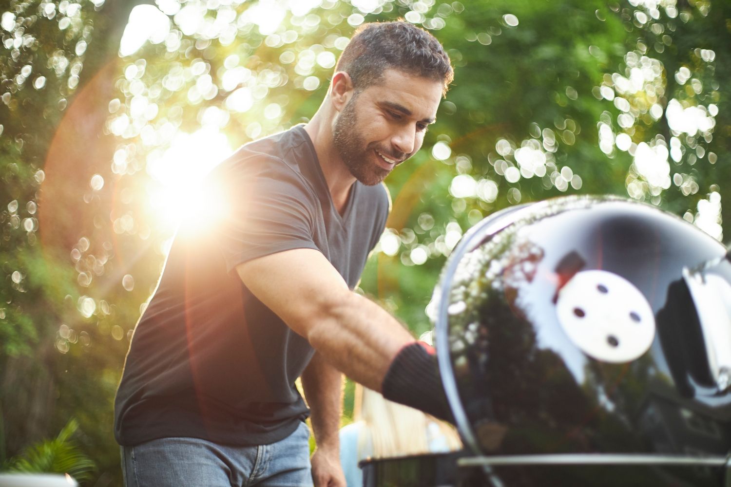 mężczyzna grillujący na grillu weber master touch