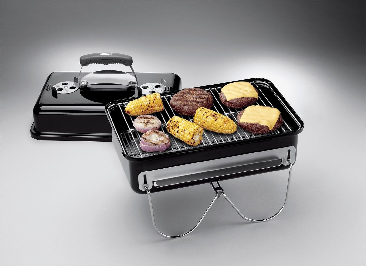 Mały grill węglowy przenośny z jedzeniem na ruszcie