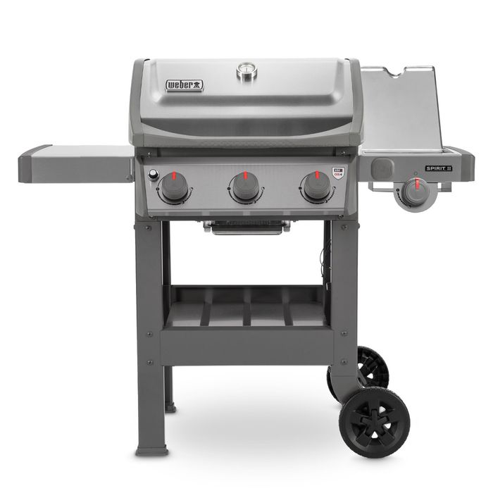 Grill gazowy Weber Spirit II S-320 GBS z szarą pokrywą i termometrem regulującym temperaturę, po bokach grilla widoczne są dwie szare półki, z przodu cztery pokrętła z czerwonym wskaźnikiem.