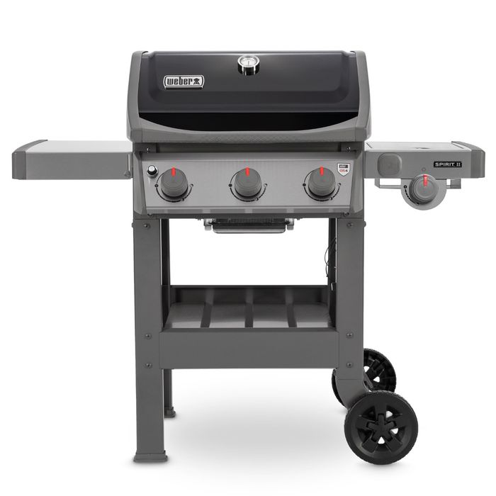 Grill gazowy Weber Spirit II E-320 GBS z czarną pokrywą i termometrem regulującym temperaturę, po bokach grilla widoczne są dwie szare półki, z przodu cztery pokrętła z czerwonym wskaźnikiem.