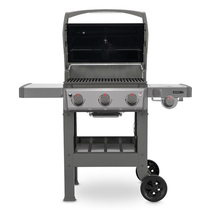 Grill gazowy Weber Spirit II E-320 GBS z czarną, podniesioną pokrywą, widoczny ruszt, po bokach grilla widoczne są dwie szare półki, z przodu cztery pokrętła z czerwonym wskaźnikiem.