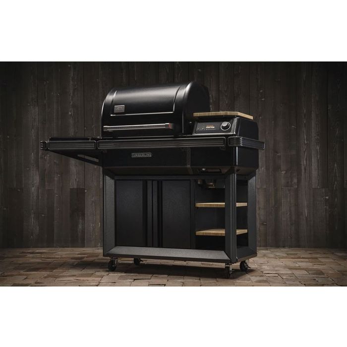 Grill na pellet Timberline INT w eleganckiej aranżacji ogrodowej, zamknięta pokrywa i boczna płyta indukcyjna.