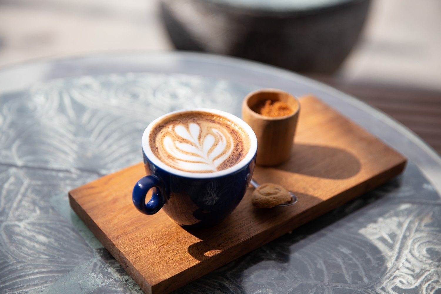 Cappuccino z przyprawami i latte art postawione na drewnianej desce